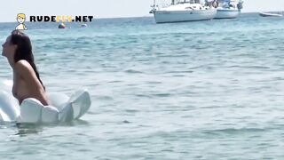 Youthful nudist with merry melons is joined by a pair on the beach